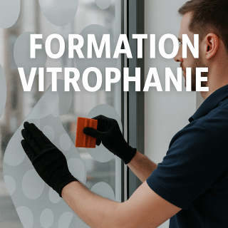 Technicien posant un film adhésif décoratif de vitrophanie sur une vitrine en verre